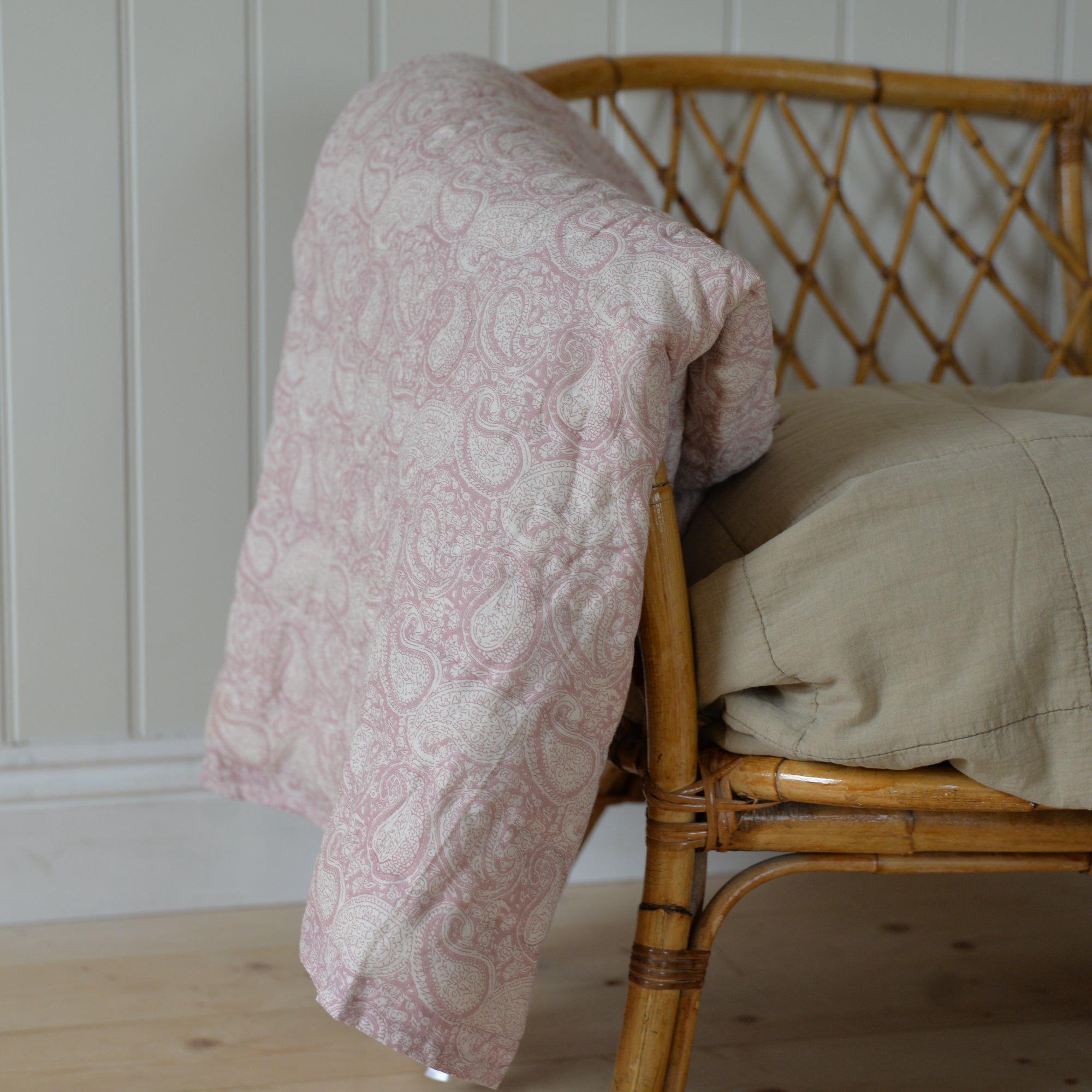A floral paisley print quilt with a rose pattern, showing its soft texture and delicate design.