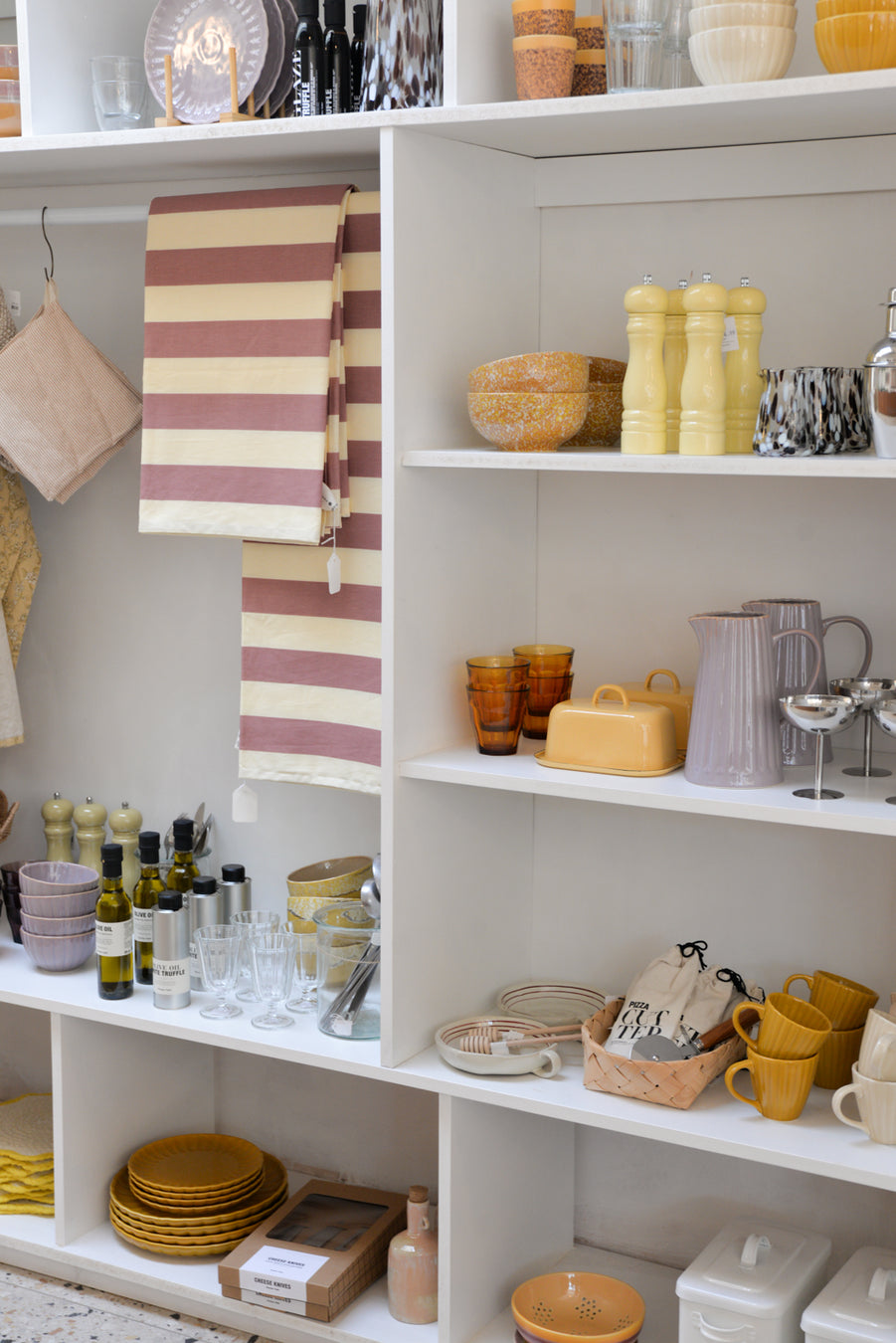 Shelves with various kitchen items including bowls, cups, and a striped towel.