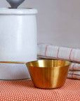 Brass coloured stainless steel measuring cup for cooking or baking designed by Bloomingville