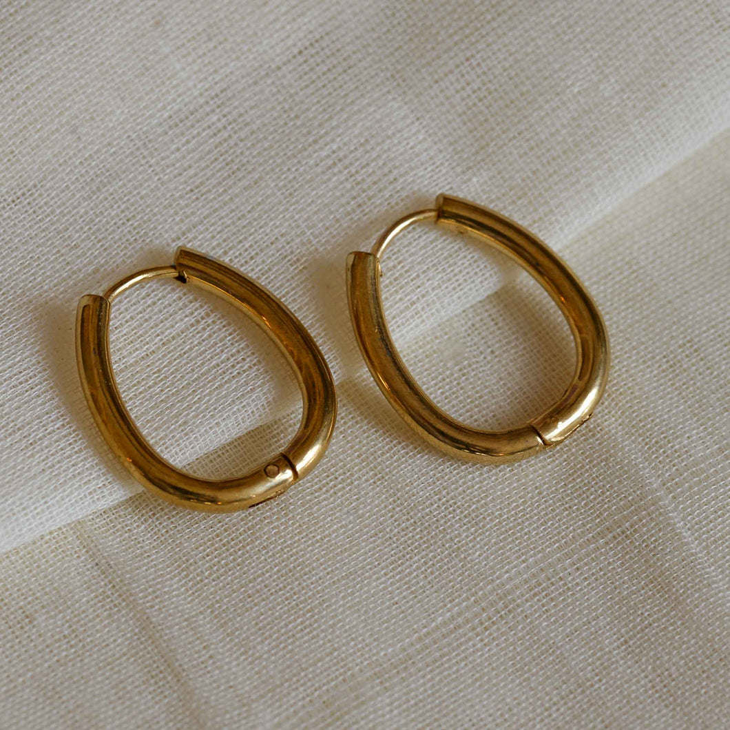 A weathered penny gold plated luna hoop lock earrings