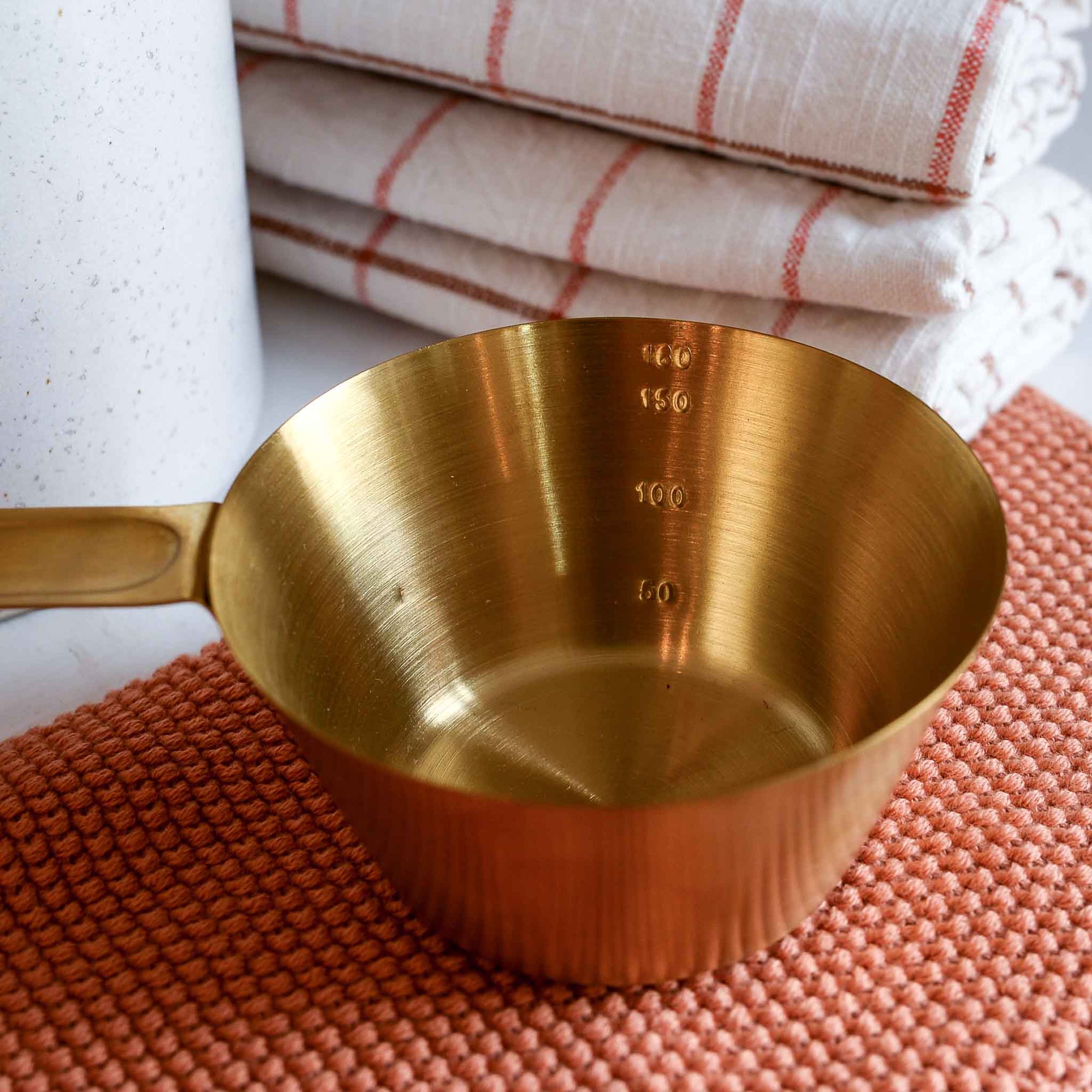 Brass coloured stainless steel measuring cup for cooking or baking designed by Bloomingville 