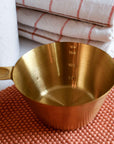 Brass coloured stainless steel measuring cup for cooking or baking designed by Bloomingville 