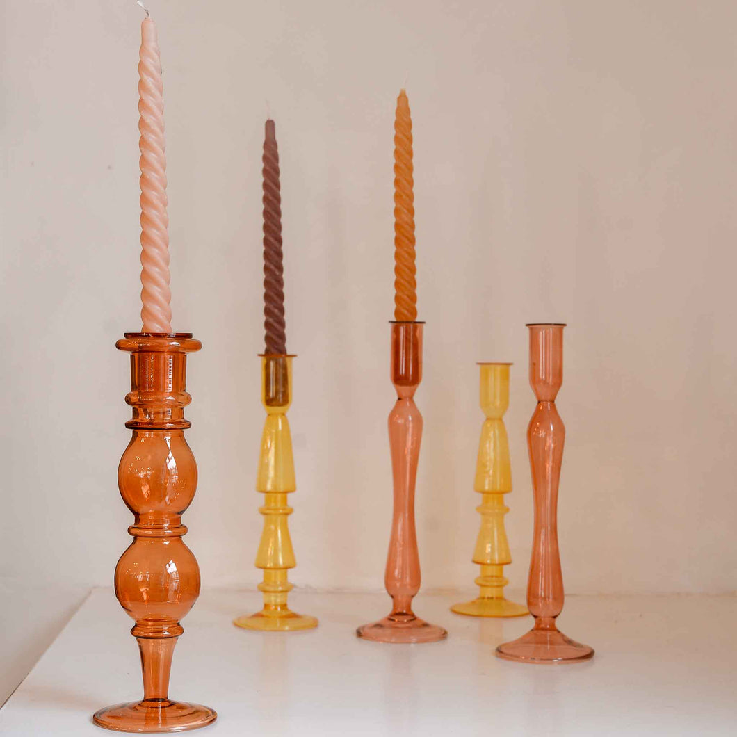 Glass candle holder by French brand A la in a coral orange colour with a wavy round shaped stem suitable for a dinner candle